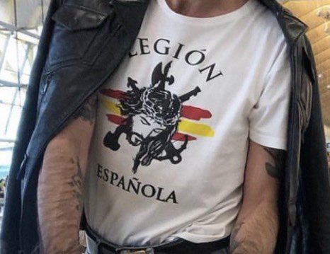 Mario Vaquerizo paseando con una camiseta de la legión por el aeropuerto de Madrid.