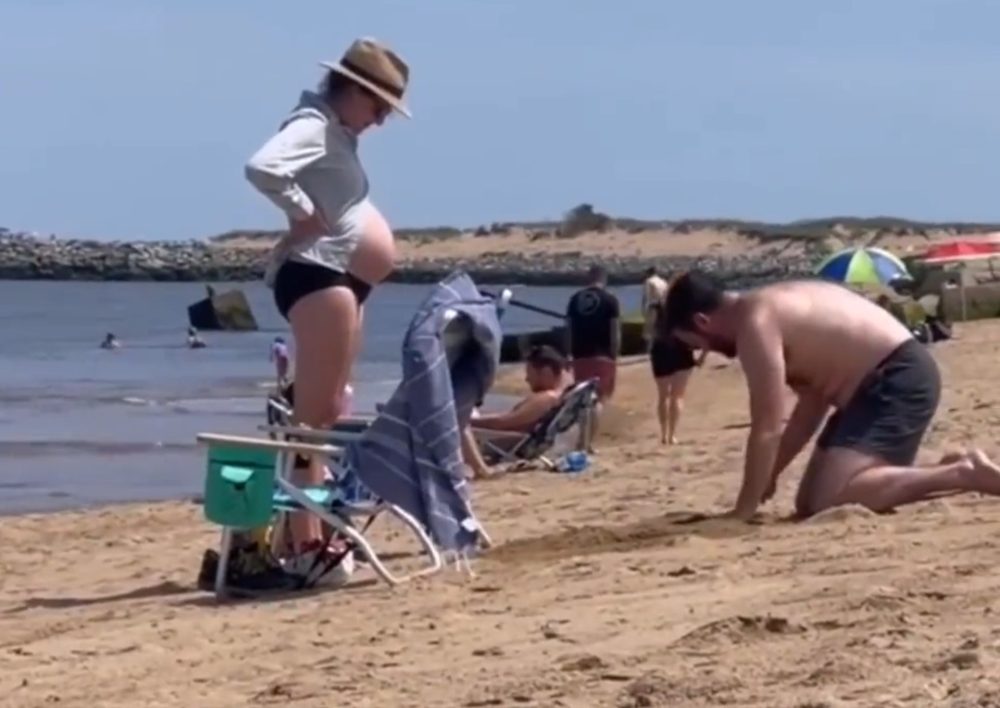 Un hombre cava un hoyo en la arena para que su pareja embarazada pudiera acostarse boca abajo.
