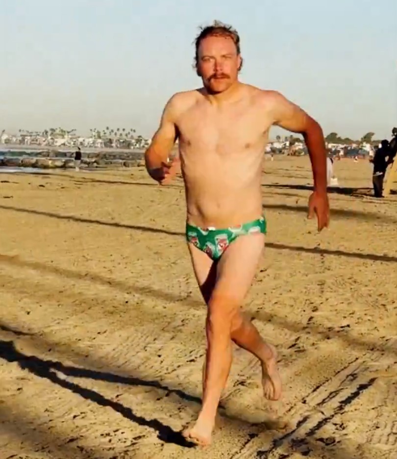 Valtteri Bottas corriendo en bañador por la arena de Newport Beach, California.