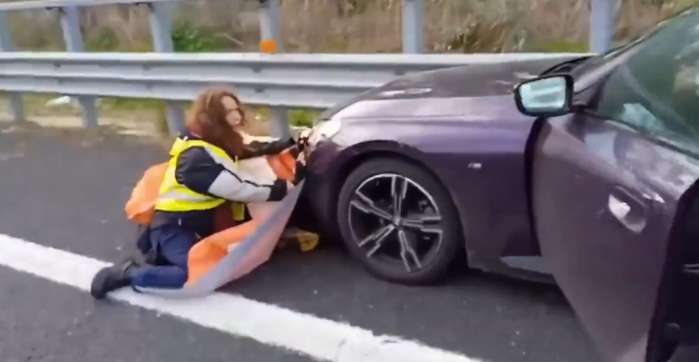 Un conductor se harta de los activistas climáticos que bloqueaban la carretera y decide apartarlos.