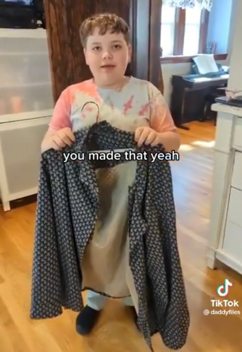 Un niño cose una camisa para su padre