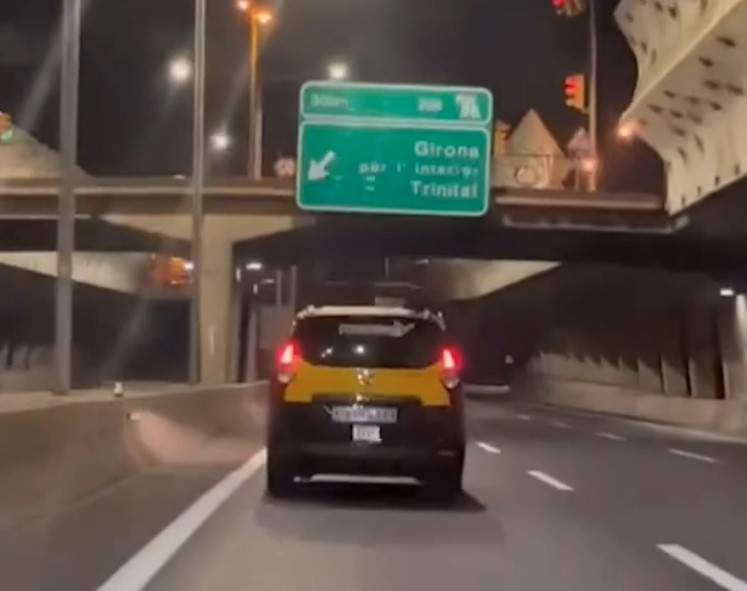 Un taxista de Barcelona conduce erráticamente mientras dos lugareños comentan la jugada.