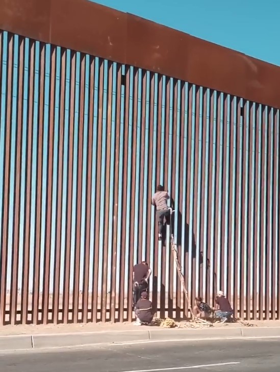 Usando escaleras piratas para salvar la valla que separa EEUU de México.