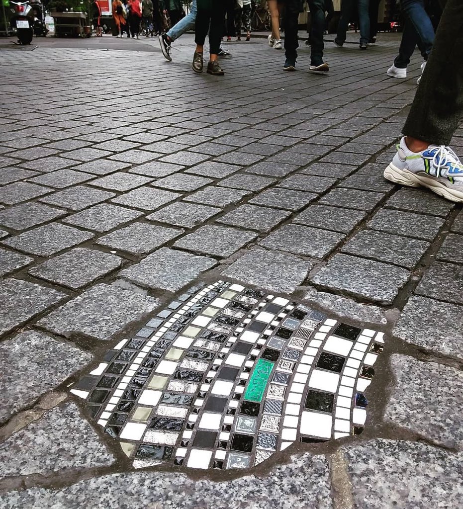 Ememem: el artista callejero que rellena desperfectos con coloridos mosaicos.