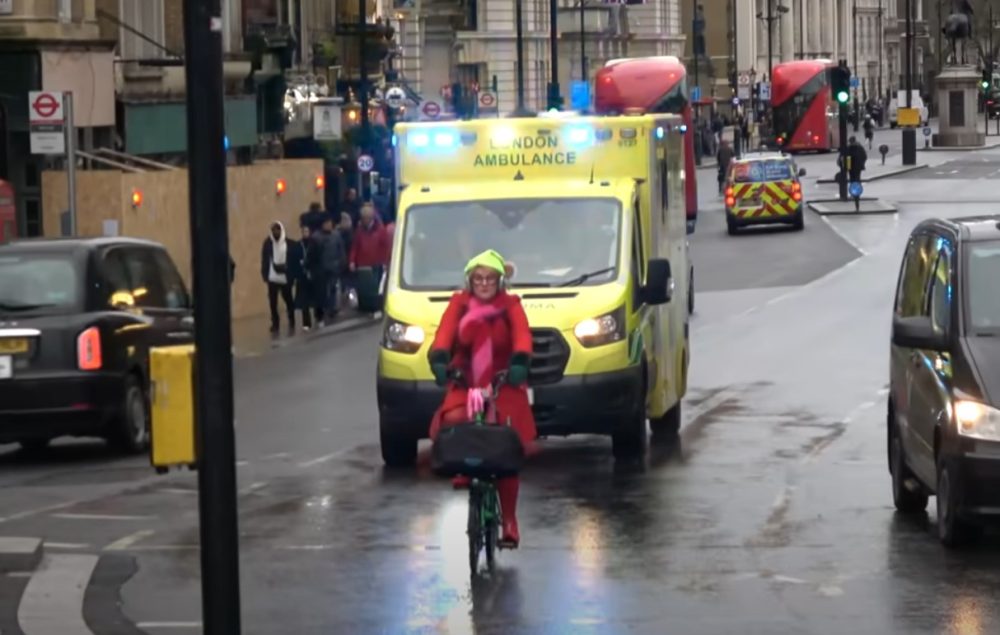 Charo Chárez bloquea a una ambulancia mientras circula con su bicicleta.