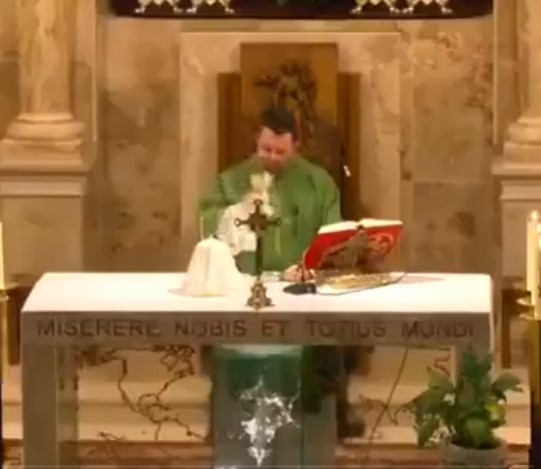 Un cura explica con desidia la logística para comulgar en la iglesia.