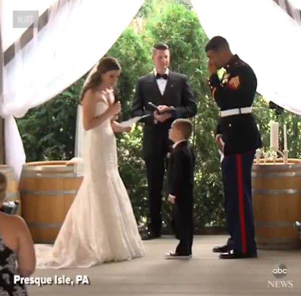 El hijo pequeño de un marine rompe a llorar mientras abraza a su nueva madrastra durante la ceremonia de la boda.