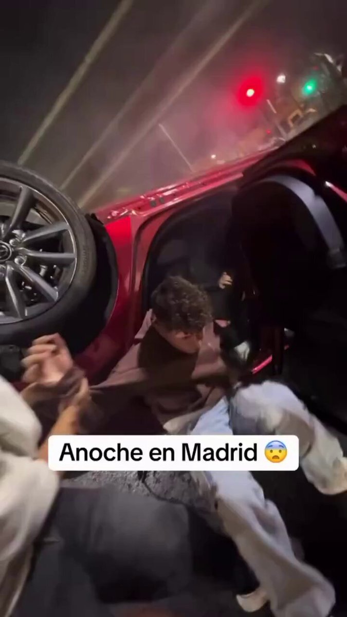 Varias personas auxilian a un grupo de jóvenes que habían volcado con el coche.