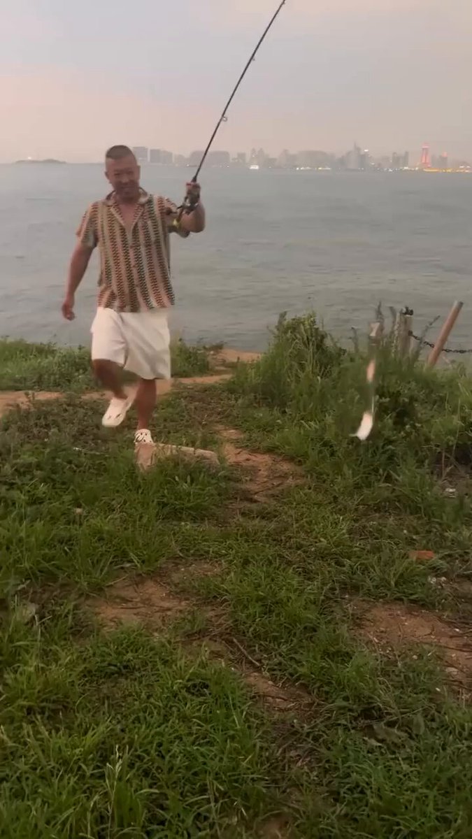 Un chino pesca un pez de acero inoxidable.