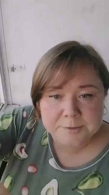 Una mujer alimenta a un halcón desde la ventana de su apartamento.