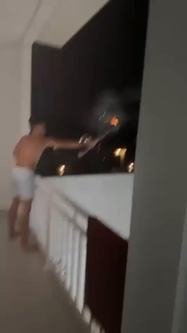 Liadita premium lanzando fuegos artificiales desde la terraza.