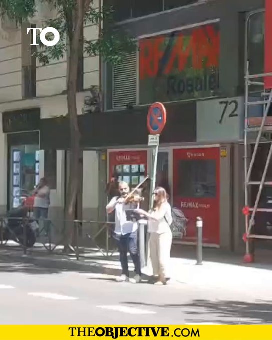 Un hombre toca el violín a las puertas de Ferraz a la espera de que los agentes de la UCO abandonen la sede del PSOE.
