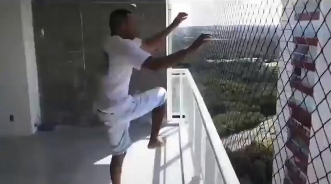 Tras instalar una red de seguridad en el balcón del piso 28, el trabajador demuestra su resistencia al cliente.