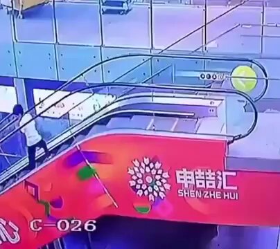 Una niña está a punto de caer desde gran altura al quedarse enganchada en el pasamanos de una escalera mecánica en un centro comercial chino.