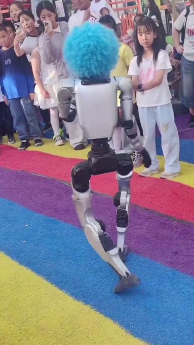 Un robot chino con una peluca de payaso patea a un niño en el estómago.